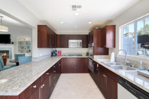 bright community kitchen with cherry brown cabinets, granite countertops, and stainless steal appliances
