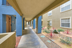 Exterior covered walkway of The Overlook at Anaheim Hills, eco friendly garden, beige and blue buildings.