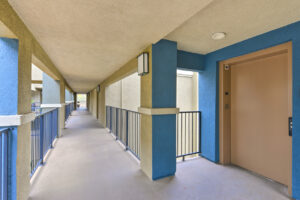 Exterior Overlook at Anaheim Hills covered pathway, beige and blue building.