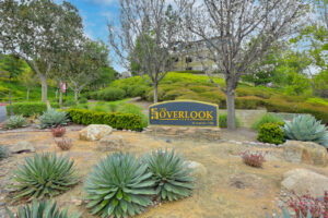 Exterior Overlook at Anaheim Hills front signage, meticulous landscaping, lush foliage, photo taken on a sunny day.